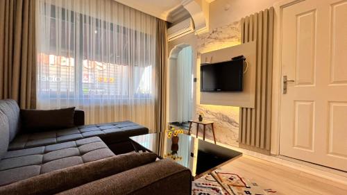 a living room with a couch and a tv and a door at Kule Apart in Istanbul