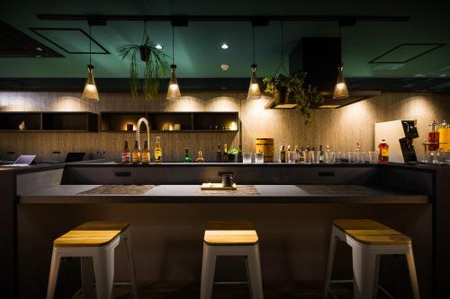 eine Bar mit zwei Hockern vor einer Theke in der Unterkunft Hotel Noir Blanc in Shizuoka