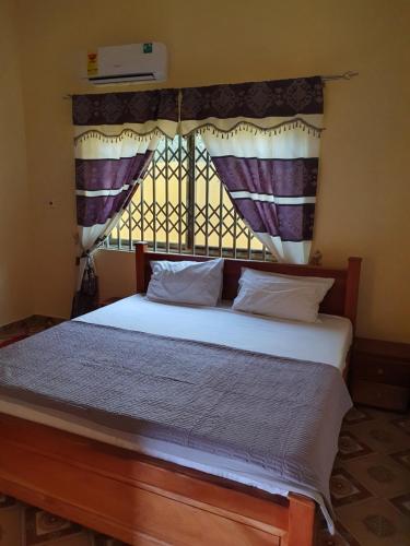 Rúm í herbergi á ROYAL APARTMENT, 2 BEDROOMS, MASTER EN-SUITE, LARGE LIVING ROOM, HOT WATER, AIR CONDITION, WIFI, BALCONY, GARDEN, SEPARATE KITCHEN, LARGE COMPOUND, CHILDREN PLAY AREA, 20 MINUTES AIRPORT, GROUND FLOOR, 24 hr SECURITY, NORTH LEGON, ACCRA