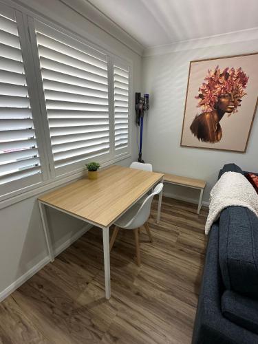 a dining room with a table and a couch at Central Evans Wagga Apartments in Wagga Wagga