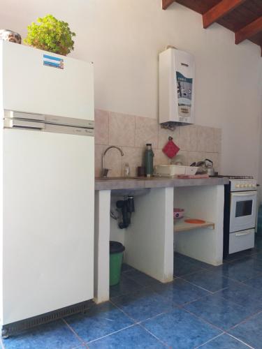 a kitchen with a white refrigerator and a sink at La Peninsula in Neuquén