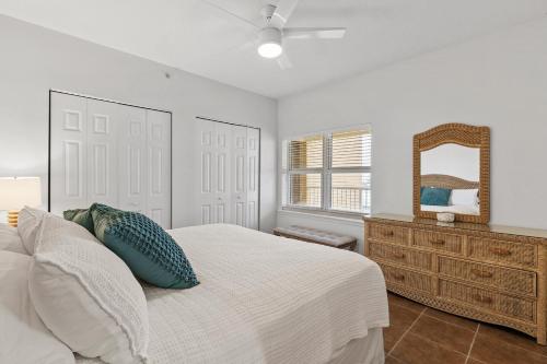 a bedroom with a bed and a dresser and a mirror at Atlantic Villas 402 in New Smyrna Beach