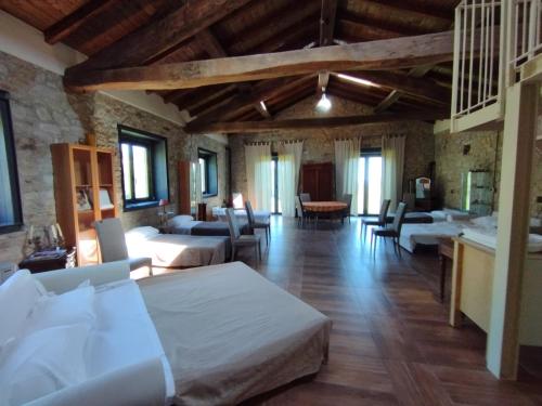 Habitación grande con varias camas y sillas. en Agriturismo Petrarosa en Neviano degli Arduini
