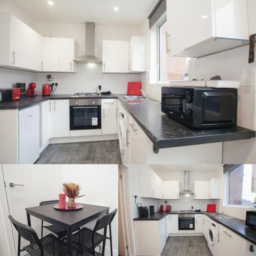 uma cozinha com armários brancos e uma mesa preta em Central Location Modern Furnishing Families and Contractors em Sheffield