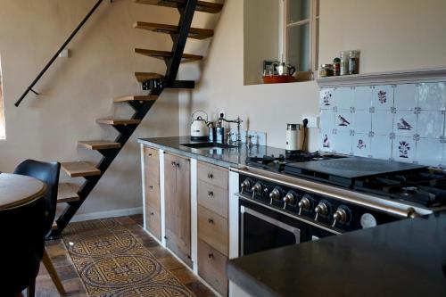 a kitchen with a stove and a spiral staircase at Spiti Espede in Ágios Márkos