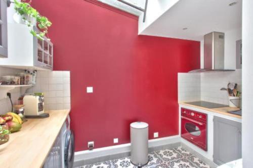 a kitchen with red walls and a red wall at Charmant 2 pièces, Paris XVe in Paris