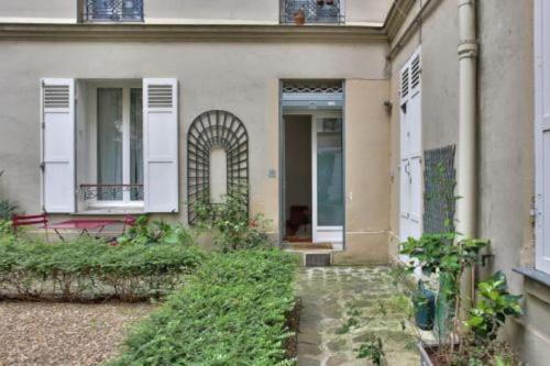 a house with a porch and a door and a porch at Charmant 2 pièces, Paris XVe in Paris