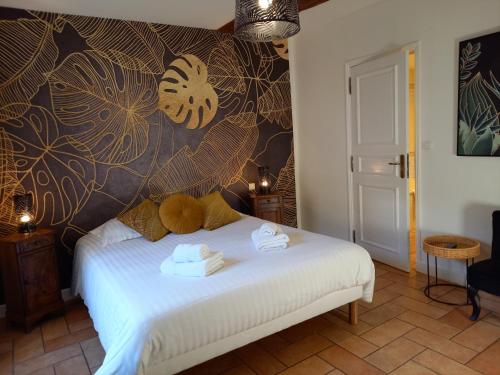 a bedroom with a bed with towels on it at Hotel de la Halle in Nolay