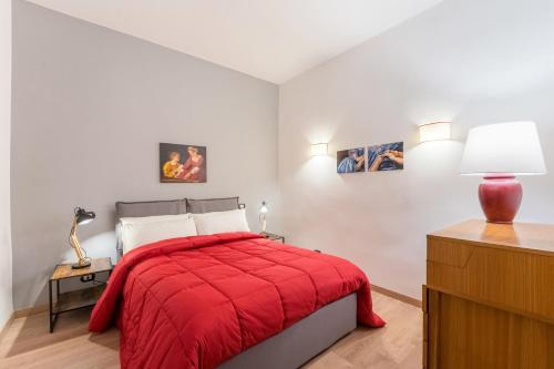 a bedroom with a red bed with a red blanket at Atelier dello Statuto, a few steps from Colosseo in Rome
