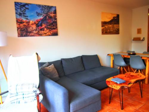 sala de estar con sofá azul y mesa en Alojamiento Rural Los Gancheros, en Tragacete