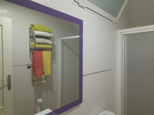 a mirror in a bathroom with towels on a wall at Apartamento Erillas in Pinos Genil
