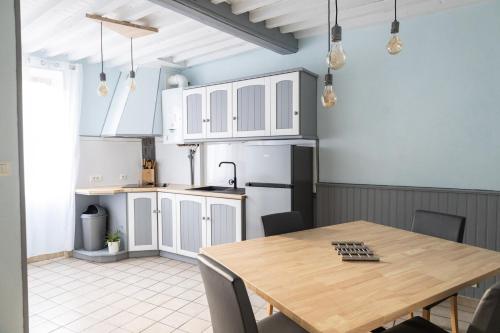 eine Küche mit einem Holztisch und einem Kühlschrank in der Unterkunft La Vigère in Mirefleurs