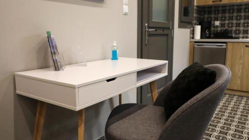 a white desk and a chair with a bottle on it at SaltHouse #4 in Kalabaka