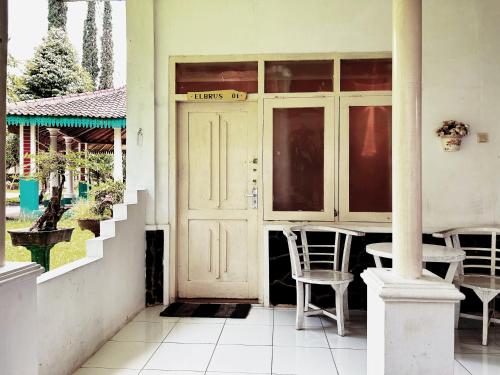 une porte d'entrée d'une maison avec une table et des chaises dans l'établissement De Karanganjar Inn, à Berni