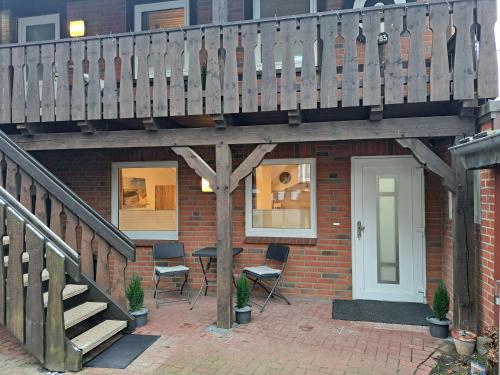 a house with a deck and a table and chairs at Ferienwohnungen Zur alten Dachdeckerei in Bad Bevensen