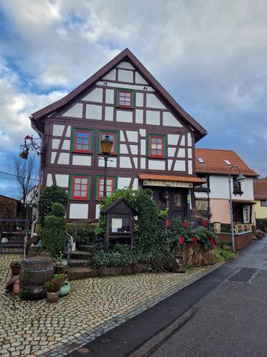 a white and black building with red windows at Ferienwohnung "Auszeit" in Tabarz