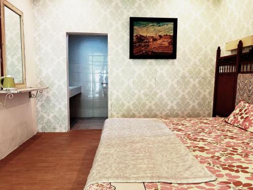 a bedroom with a bed and a walk in shower at De Karanganjar Inn in Berni