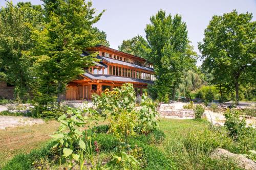une maison en bois avec un jardin en face dans l'établissement Guest House Mala Prica, à Živinice