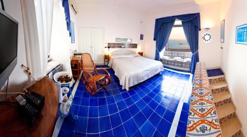 a bedroom with a blue tiled floor with a bed at Villa Angelina in Massa Lubrense