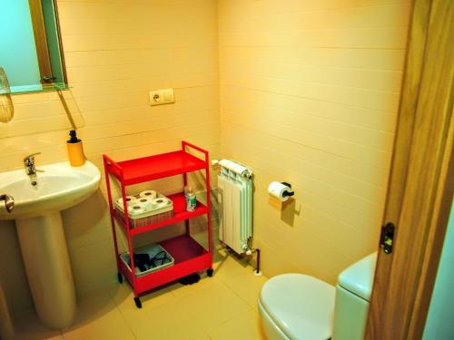 Baño con estante rojo junto a un lavabo en Las Colmenillas 1, en Tragacete