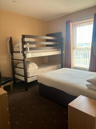 a bedroom with two bunk beds and a window at The Beechfield Hotel in Blackpool