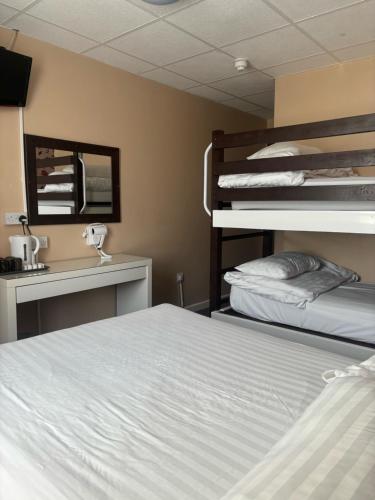 a bedroom with two bunk beds and a mirror at The Beechfield Hotel in Blackpool
