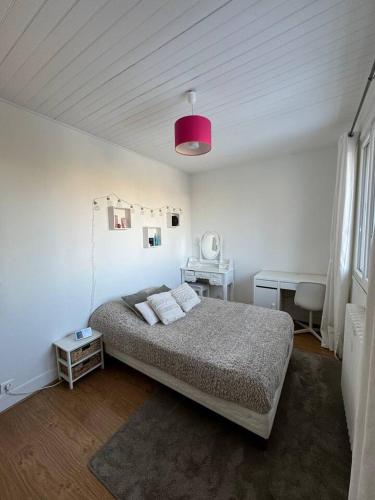 ein Schlafzimmer mit einem Bett und einer rosa Lampe in der Unterkunft Grande Maison, 10 mn stade JO in Rueil-Malmaison