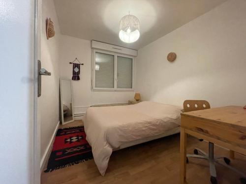 1 dormitorio con cama, escritorio y ventana en Superbe maison, confort calme et pratique, en Cergy