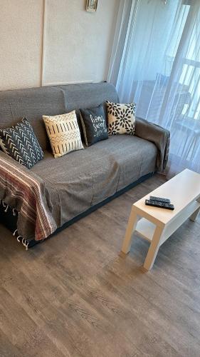 a living room with a couch and a coffee table at Studio vue port, parking privé, terrasse, clim in Le Grau-du-Roi