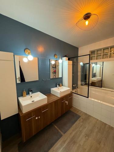 ein großes Badezimmer mit zwei Waschbecken und einer Badewanne in der Unterkunft Grande Maison, 10 mn stade JO in Rueil-Malmaison