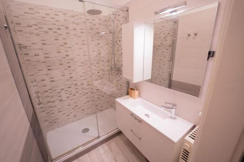 ein weißes Bad mit einem Waschbecken und einer Dusche in der Unterkunft La Rosa Dei Venti Comfort Home in Triest