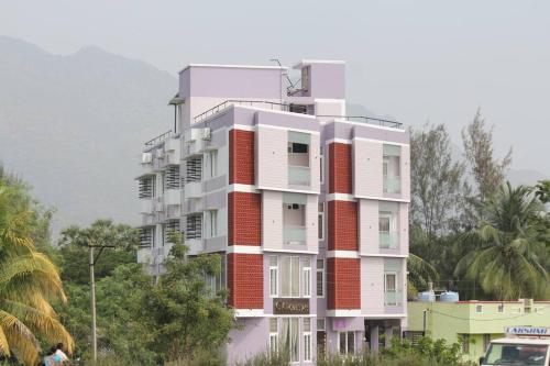 a tall white building with red bricks at GK Homestays - Luxurious Furnished Apartment in Salem