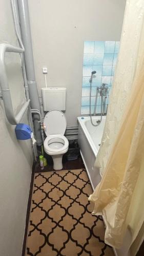 W łazience znajduje się toaleta, wanna i prysznic. w obiekcie Чистая и уютная квартира в 6-ом микрорайоне w mieście Taraz
