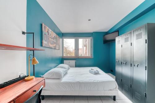 a bedroom with a bed and a blue wall at Atelier-Gerland in Lyon