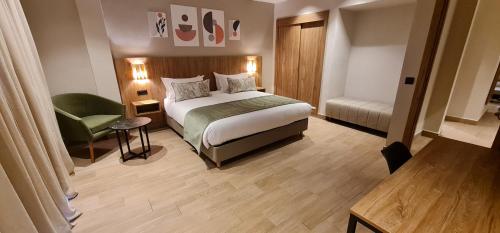 ein Hotelzimmer mit einem Bett und einem Stuhl in der Unterkunft L'escale Hôtel & Spa By 7AV HOTELS in Ouazzane