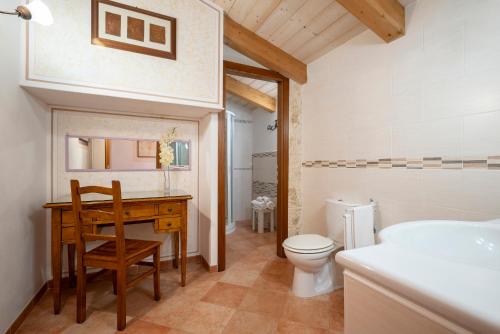 a bathroom with a desk and a toilet and a sink at Lola Piccolo Hotel e Appartamenti in Marina di Grosseto