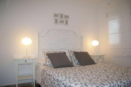 um quarto com uma cama com duas mesas e dois candeeiros em Garrucha's Beach Aldea Marina em Vera
