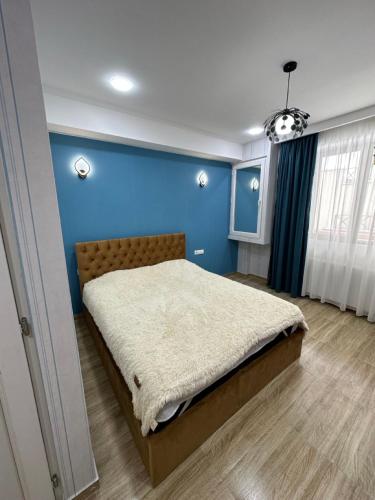um quarto com uma parede azul e uma cama em Bakuriani Mix 213 em Bakuriani