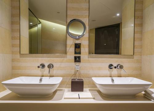 uma casa de banho com 2 lavatórios e um espelho em HomesGetaway-Lavish1BR in Hyatt Regency Creek Heights Residences em Dubai