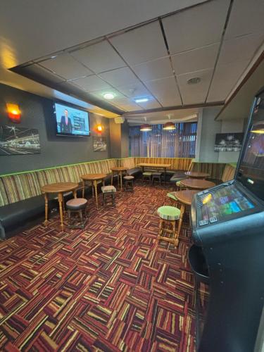 a room with tables and chairs and a video game at The Lawton in Blackpool