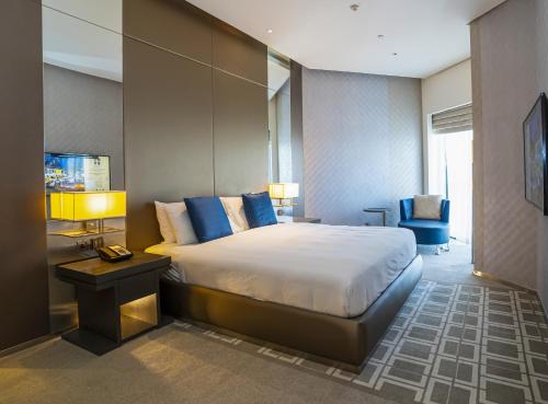 um quarto com uma cama grande e almofadas azuis em HomesGetaway-Lavish1BR in Hyatt Regency Creek Heights Residences em Dubai