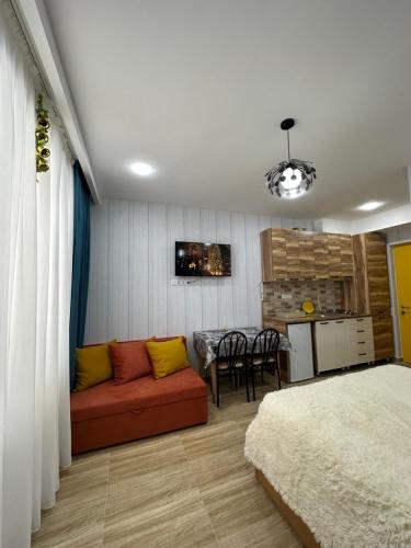 uma sala de estar com um sofá vermelho e uma cozinha em Bakuriani Mix 213 em Bakuriani