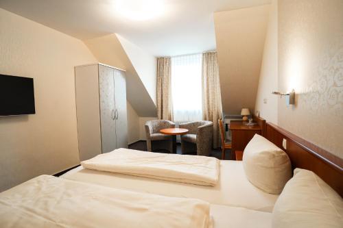 a hotel room with a bed and a chair at Trip Inn Parkhotel Bad Ems in Bad Ems