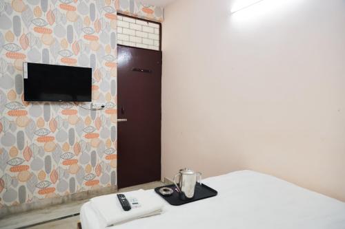 Habitación con cama y TV en la pared. en Hotel In laxmi nagar - Mannat Stay, en Nueva Delhi