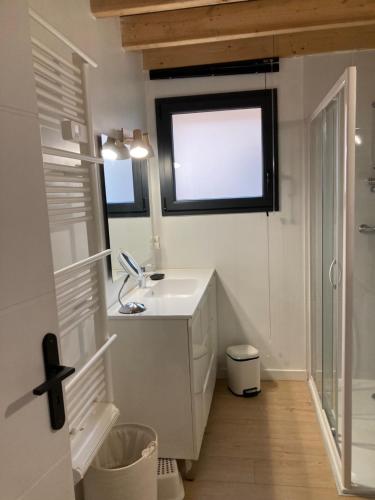 a bathroom with a sink and a window at CHALET ARIZONA - AU COTTAGE DU MEDOC - Proche de BORDEAUX in Saint-Aubin-de-Médoc