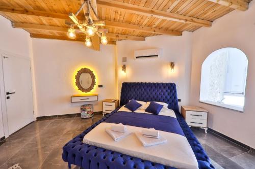 1 dormitorio con cama azul y ventana grande en Villa Sandak 1 en Bulmaç