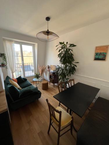 un salon avec une table et un canapé dans l'établissement Charmant deux pièces typiquement parisien, à Paris