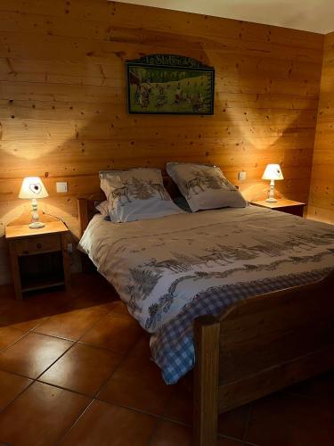 une chambre avec un lit dans une cabane en rondins dans l'établissement Chalet Coquelicot - confort montagnard et ambiance chaleureuse au cœur de Saint Martin de Belleville, à Saint-Martin-de-Belleville