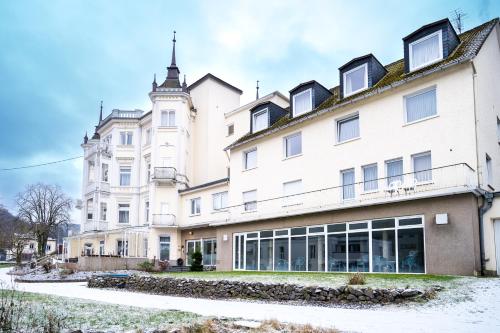 a large white building with a clock tower at Trip Inn Parkhotel Bad Ems in Bad Ems