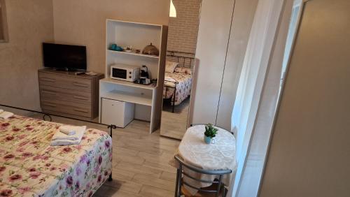 a small room with a bed and a microwave at La Casa di Mimmo in Gradara
